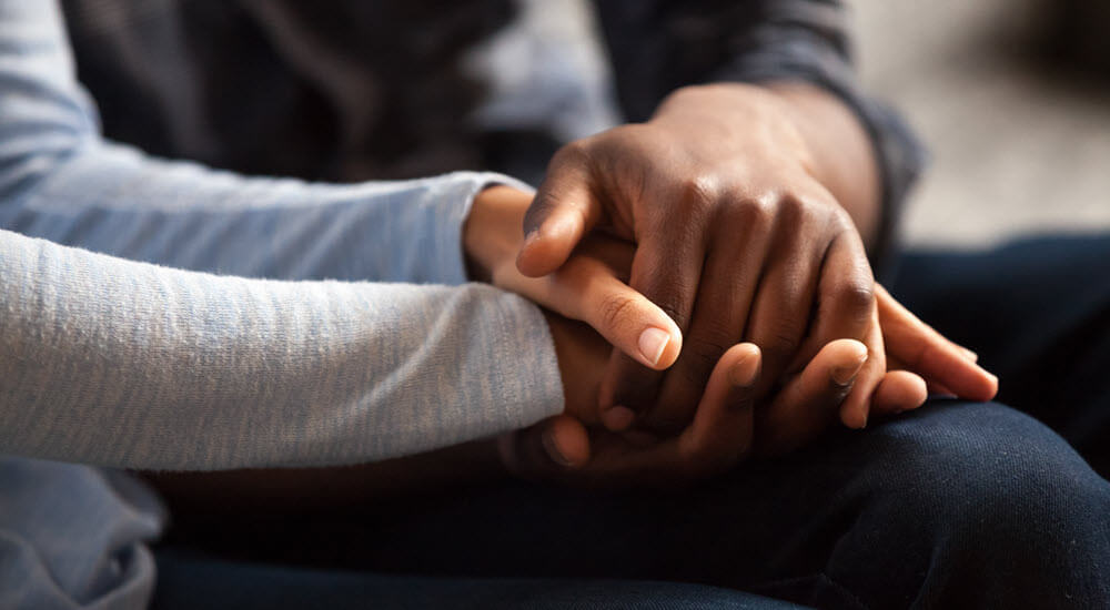 Two people holding hands together